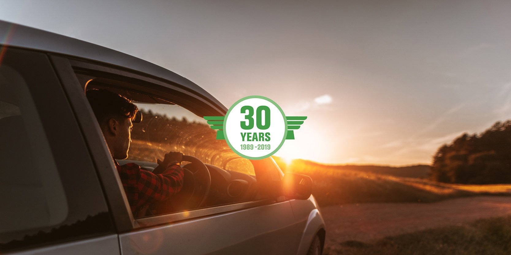 A happy customer drives into the sunset in a Pegasus NZ rental car.