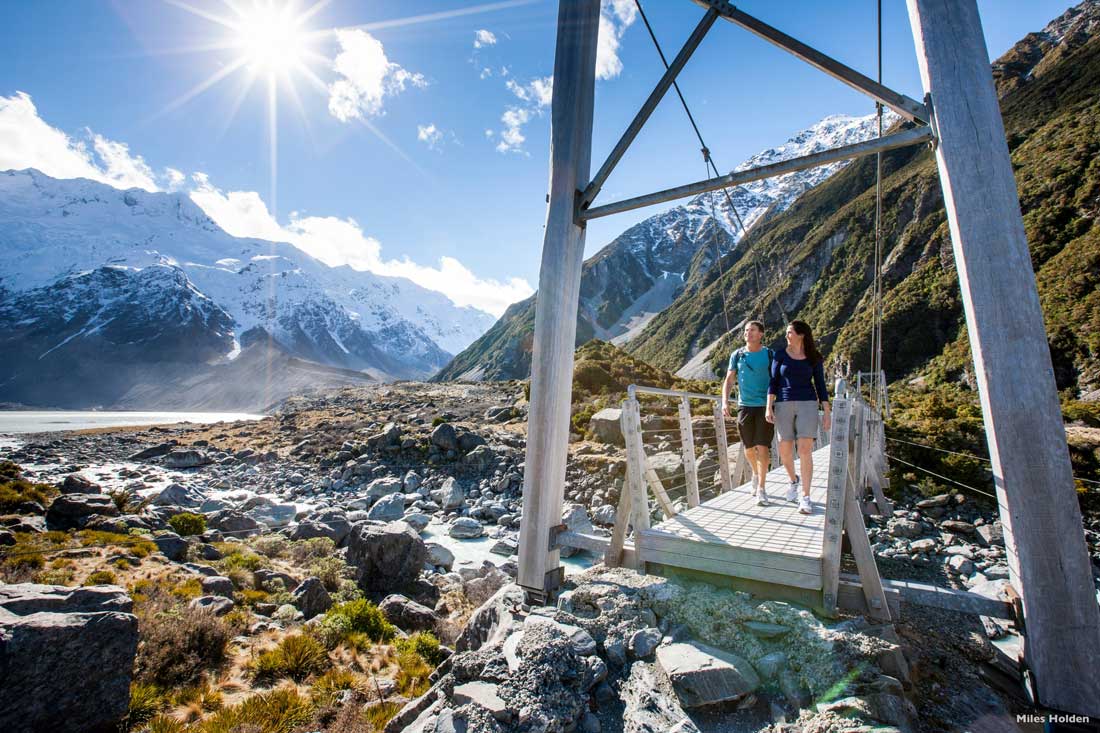 Crossing a bridge in stunning sunshine in Aoraki Mt Cook National Park