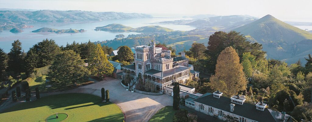 View from a hill top overlooking Larnach Castle and out to the ocean