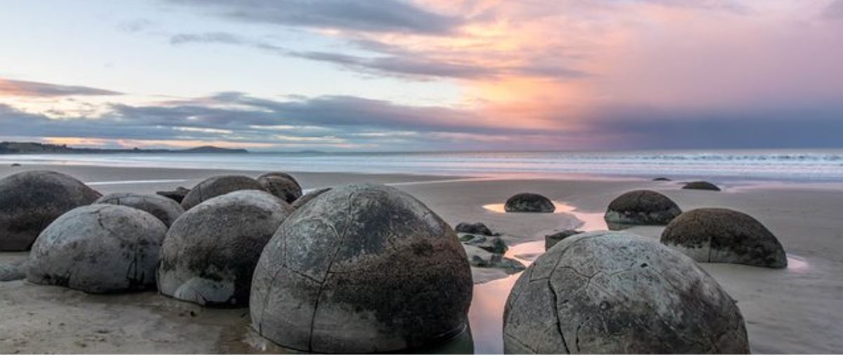 boulders along the Moeraki Boulders Beach during sunrise. 