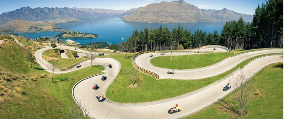 people enjoying a high speed luge circuit high above Queenstown city.